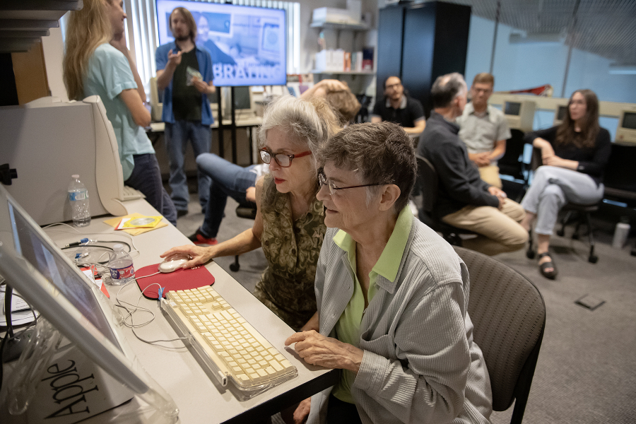 Dene Grigar and Stephanie Strickland view electronic literature on a vintage Macintosh